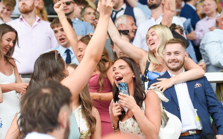 A group of friends in the grandstands at Uttoxeter Racecourse celebrating the races